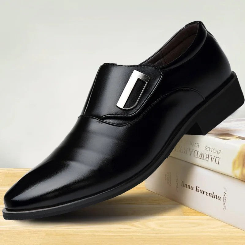 Black dress shoe with a silver buckle on a light background