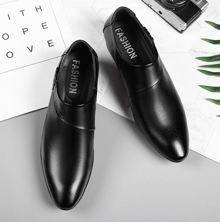 Black dress shoes on a white surface with text and green leaves in the background