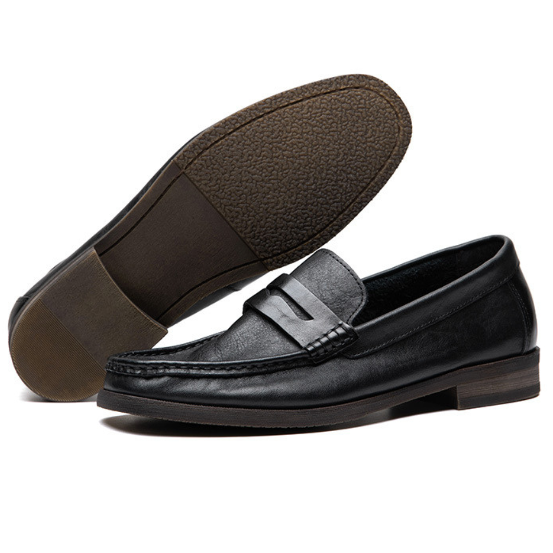 Black leather loafer shoes on a white background
