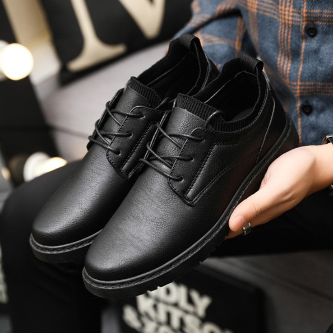 Black leather shoes with a guy showing them