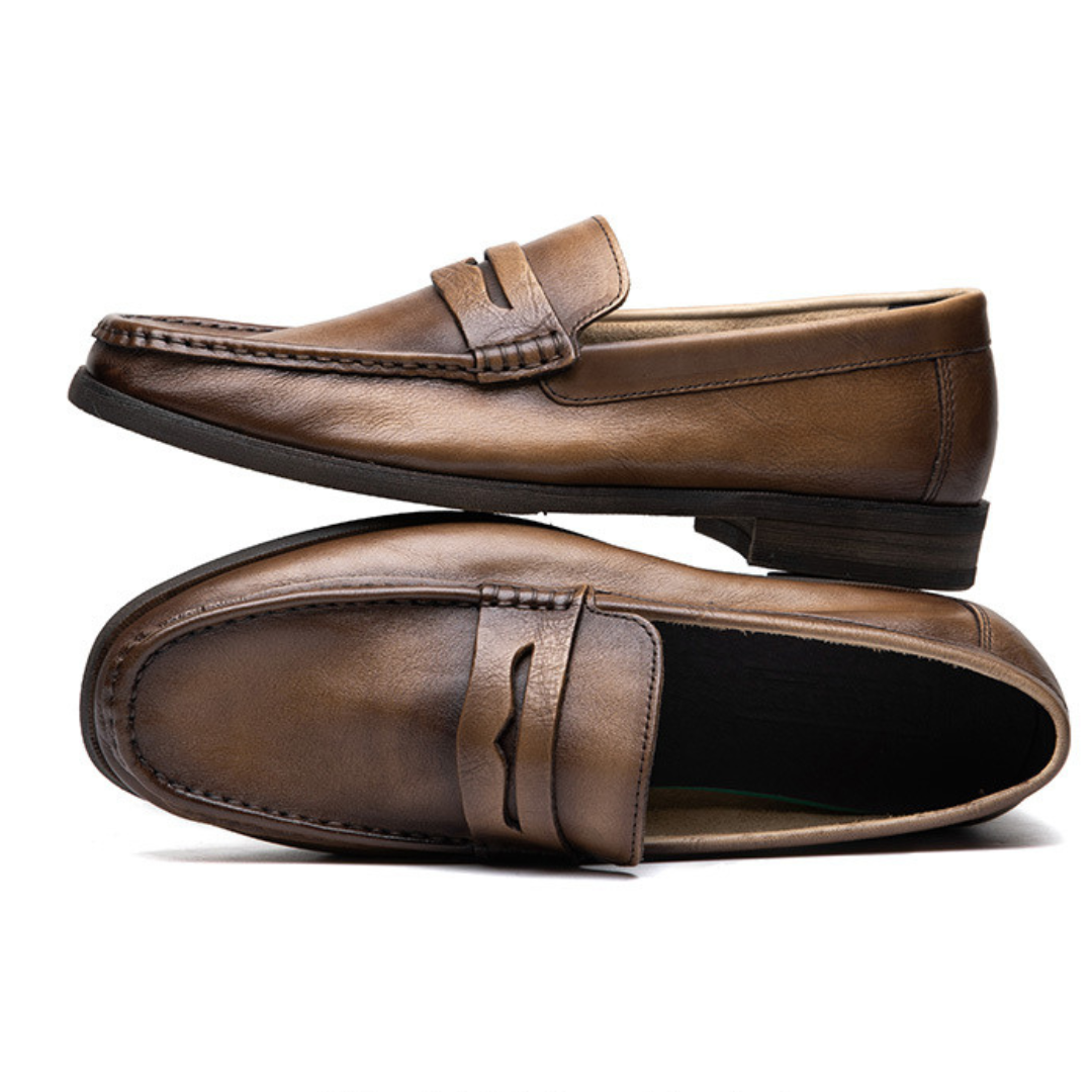 Pair of brown leather loafers on a white background